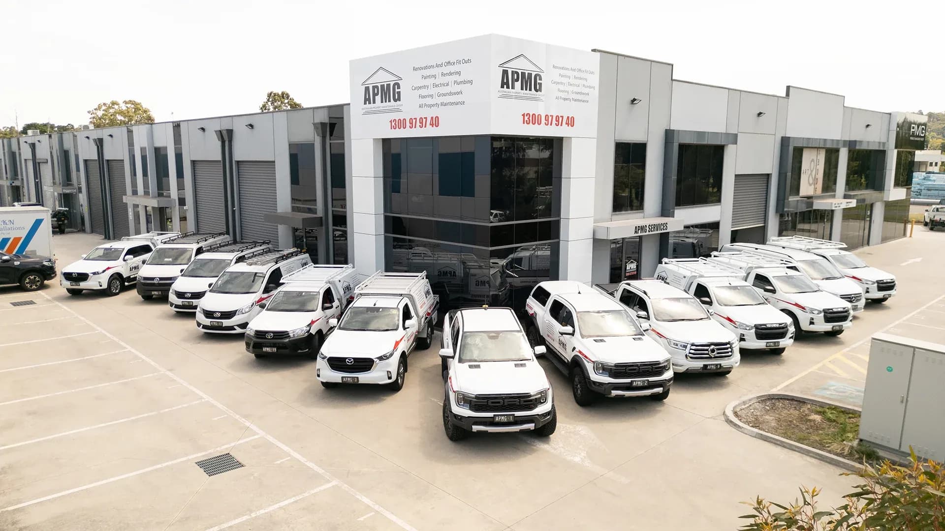 The depot, its signage carrying the 1300 number, with the work fleet parked across the forecourt